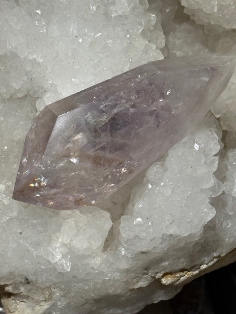 Double-terminated point in pale fluorescent amethyst