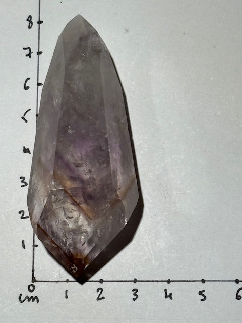 Double-terminated point in pale fluorescent amethyst