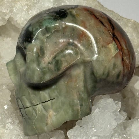 Crâne en émeraude verte avec inclusions de bixbite (émeraude rouge)