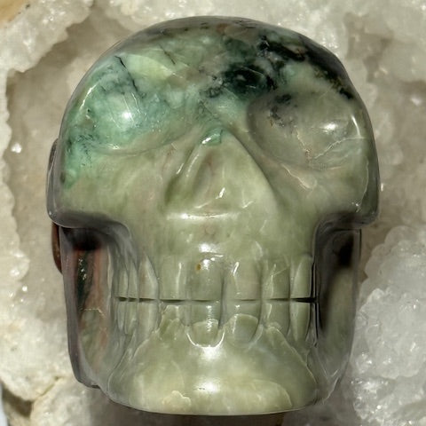 Crâne en émeraude verte avec inclusions de bixbite (émeraude rouge)