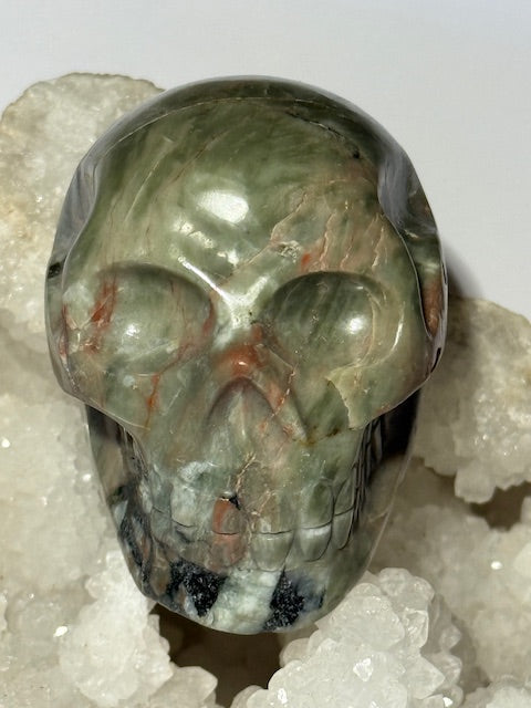 Crâne en émeraude verte avec inclusions de bixbite (émeraude rouge)