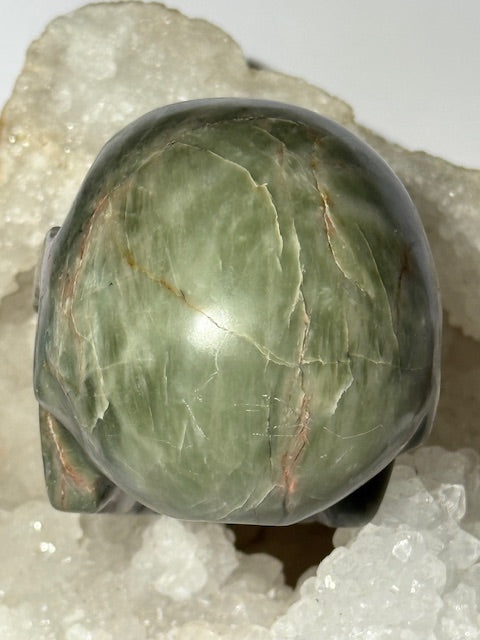 Crâne en émeraude verte avec inclusions de bixbite (émeraude rouge)