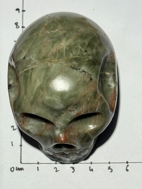 Crâne en émeraude verte avec inclusions de bixbite (émeraude rouge)