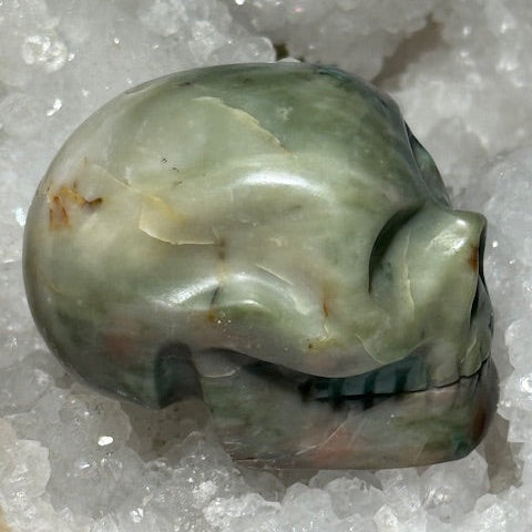 Crâne en émeraude verte avec inclusions de bixbite (émeraude rouge)